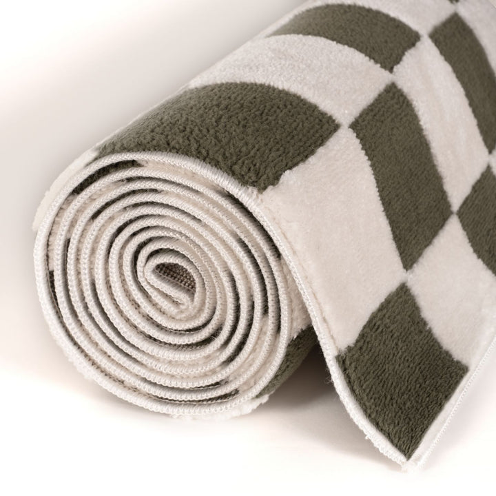 Rolled-up checkered rug with green and beige pattern on a white background