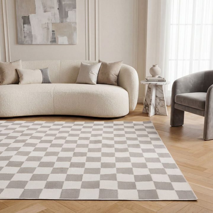 Living room with a checkered rug, beige sofa, and gray armchair.