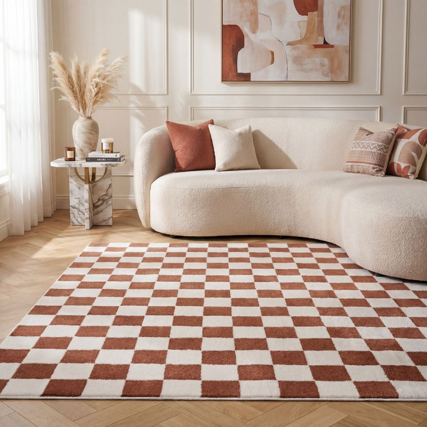 Living room with a checkered rug, beige sofa, and abstract painting.