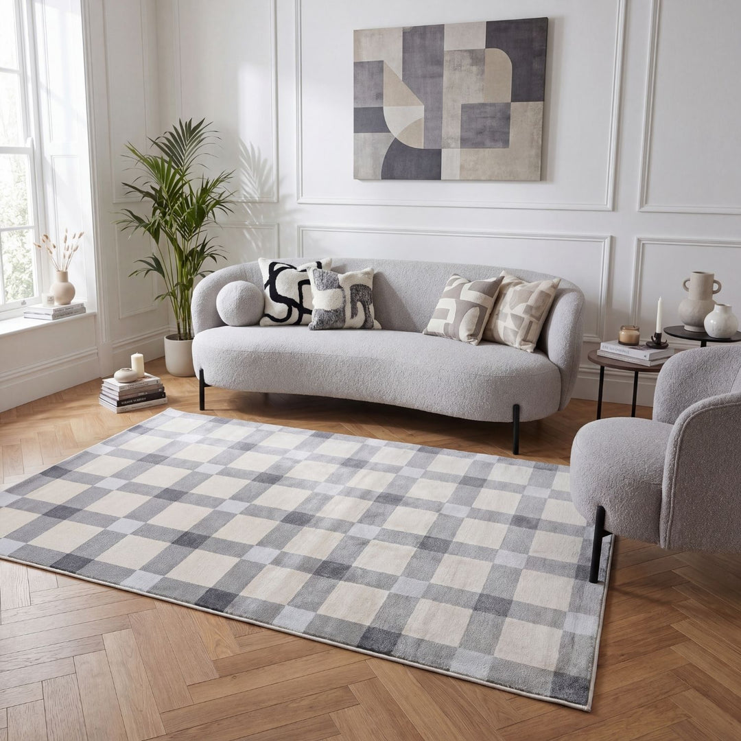 Living room with a checkered rug, gray sofa, and abstract painting on the wall.