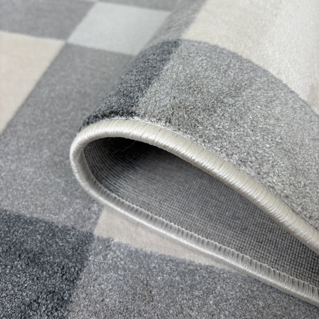 Gray checkered rug with a textured edge