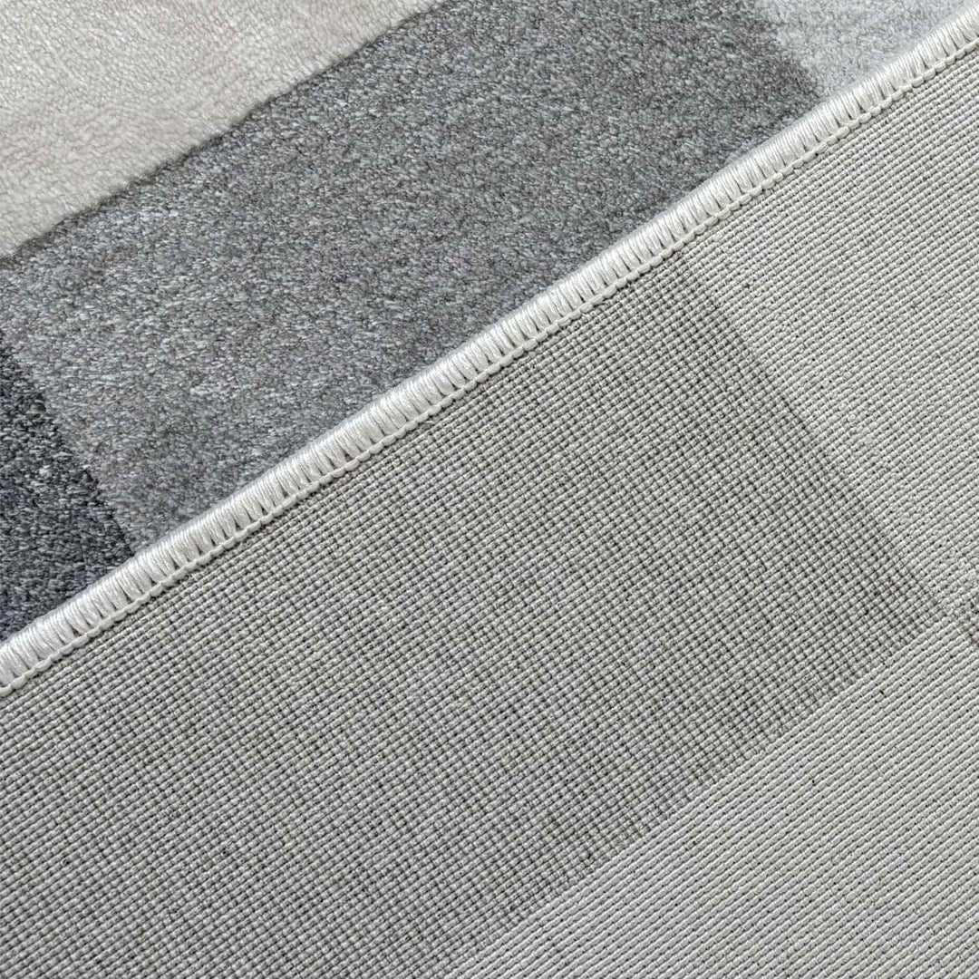 Close-up of a textured gray rug with a geometric pattern