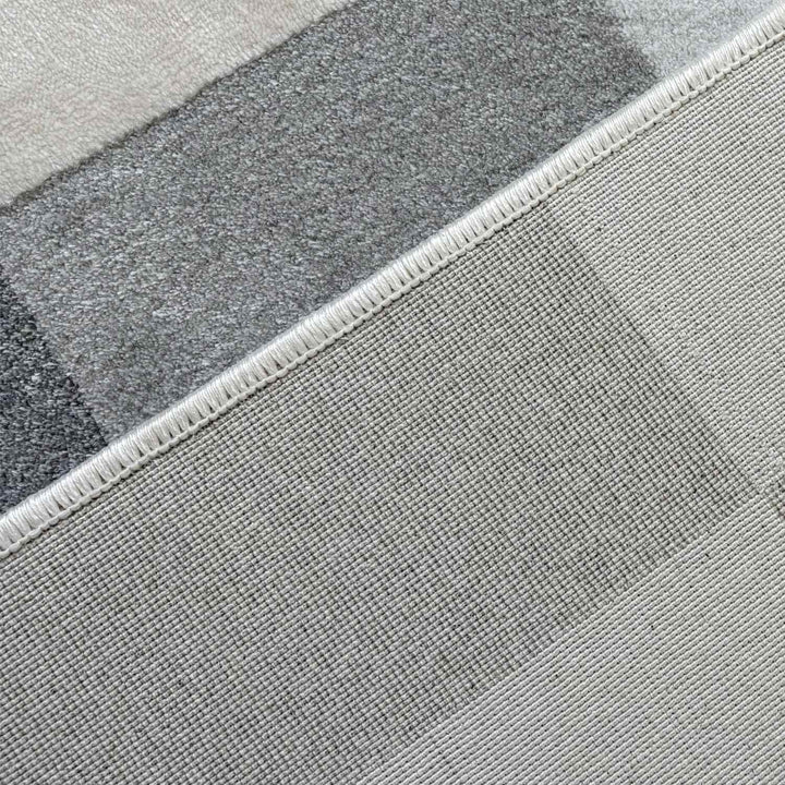 Close-up of a textured gray rug with a geometric pattern