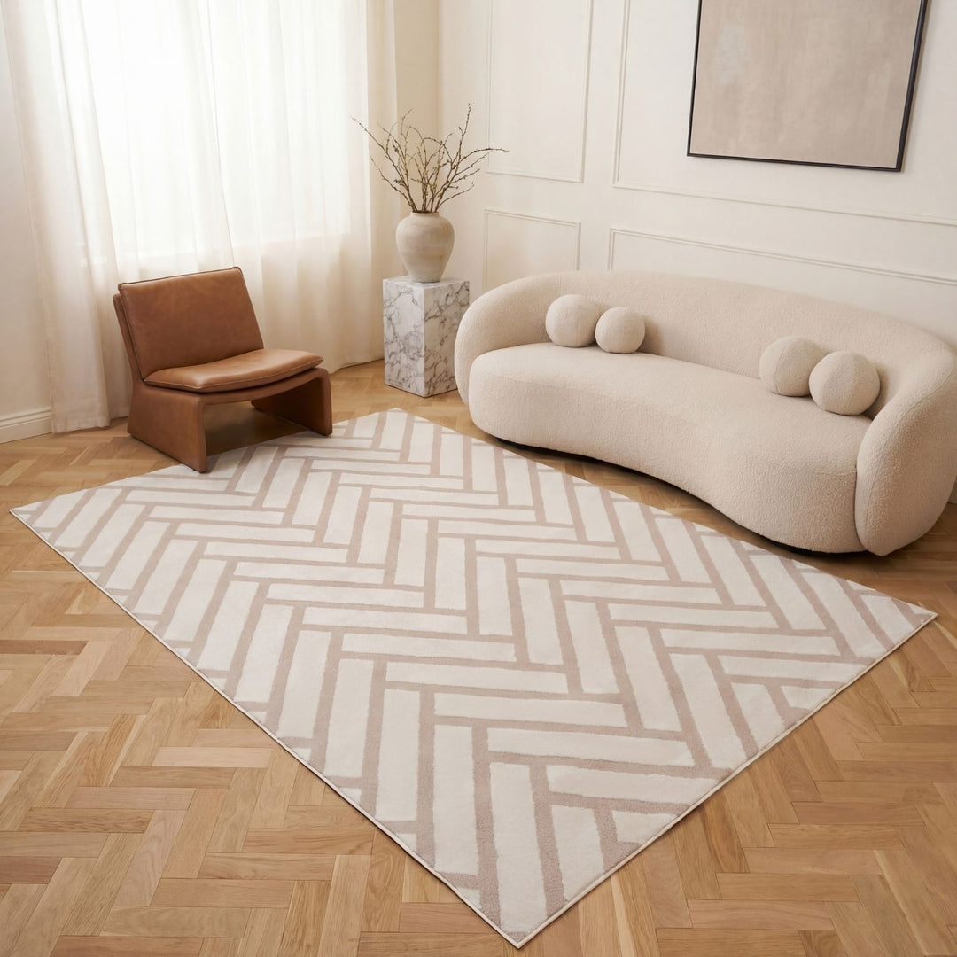 Modern living room with a chevron patterned rug, beige sofa, and brown chair.