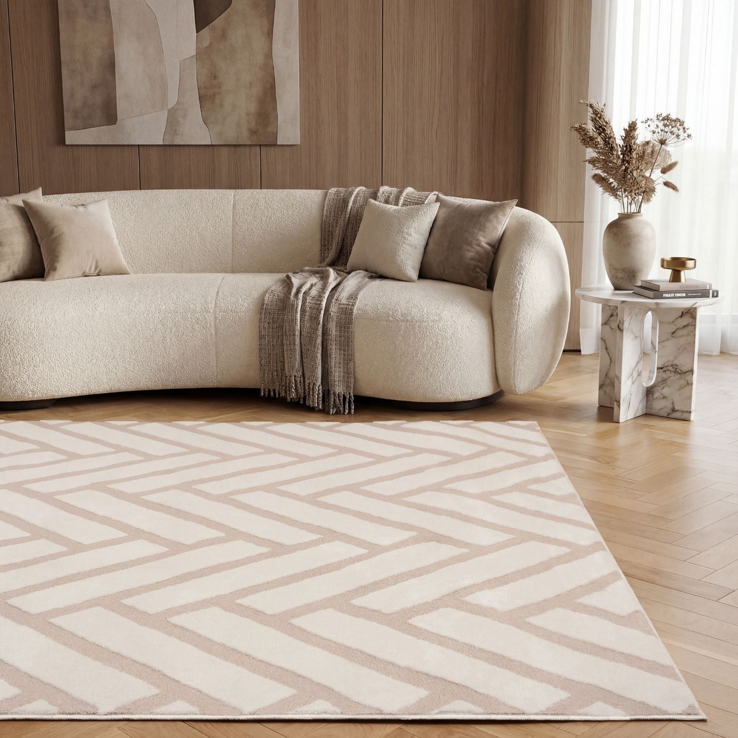 Modern living room with a beige sofa, patterned rug, and abstract art on the wall.