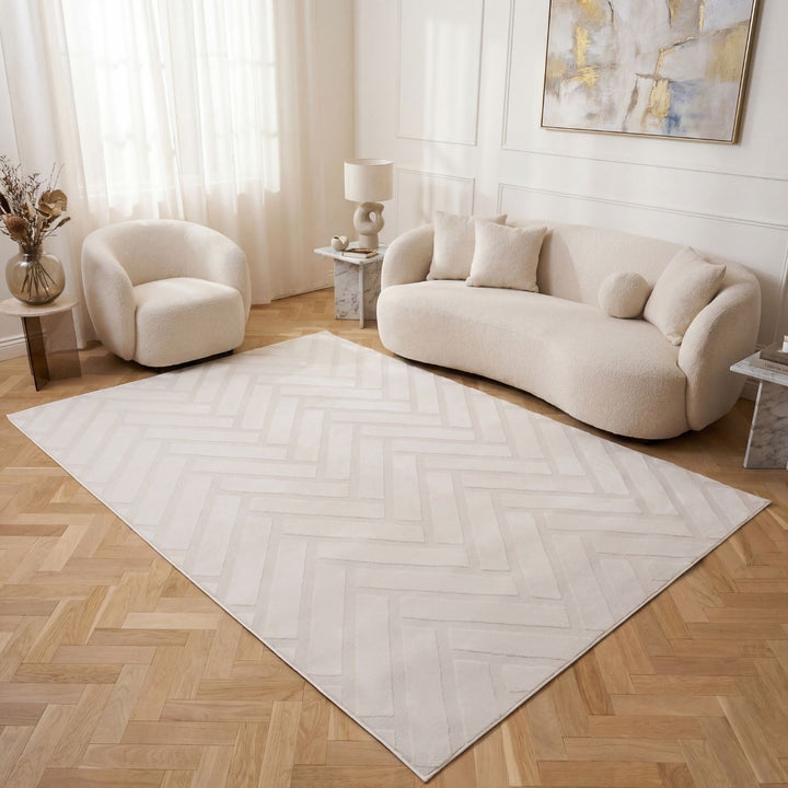 Living room with a beige sofa, armchair, and a large white rug on wooden flooring.