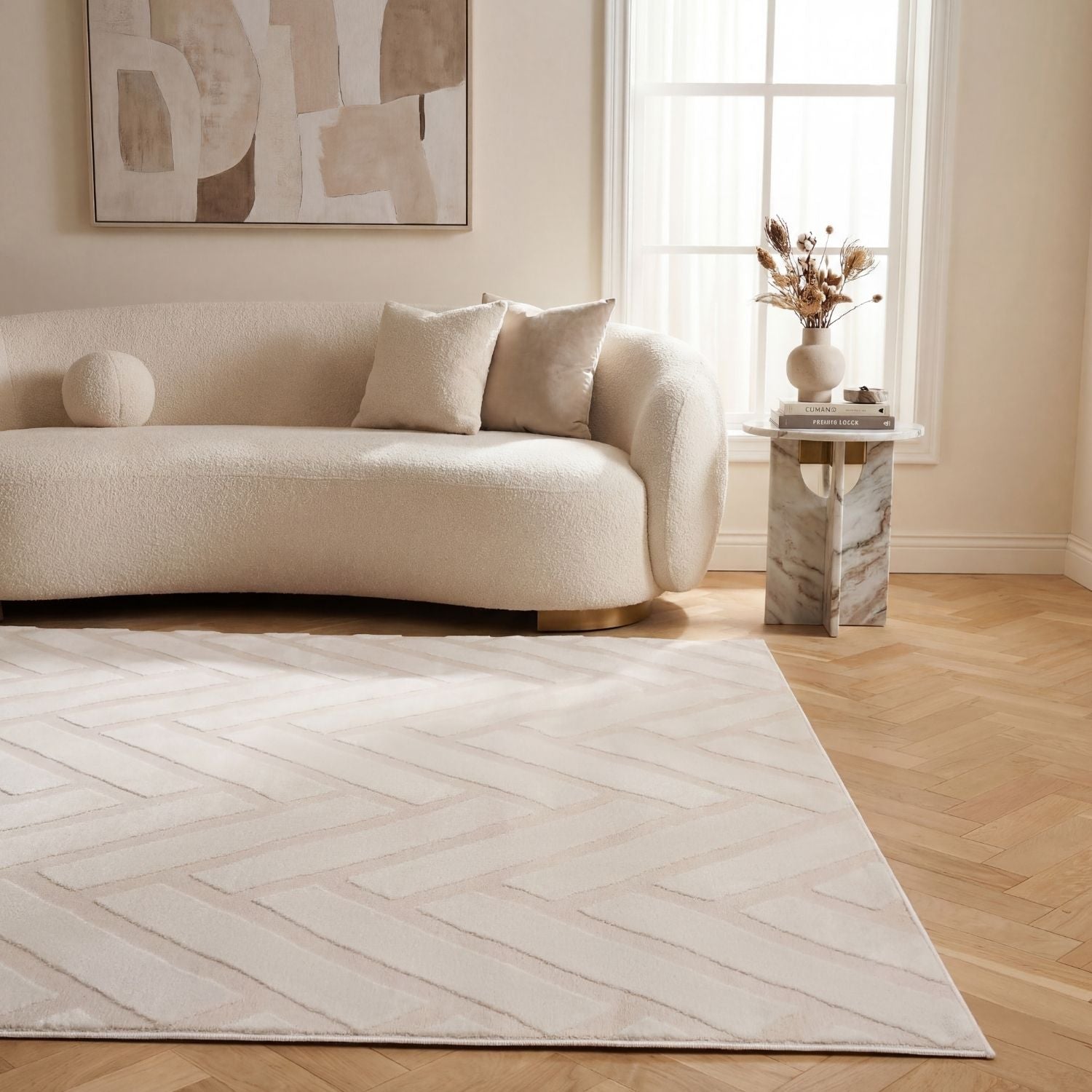 Modern living room with a beige sofa, abstract art, and a patterned rug.