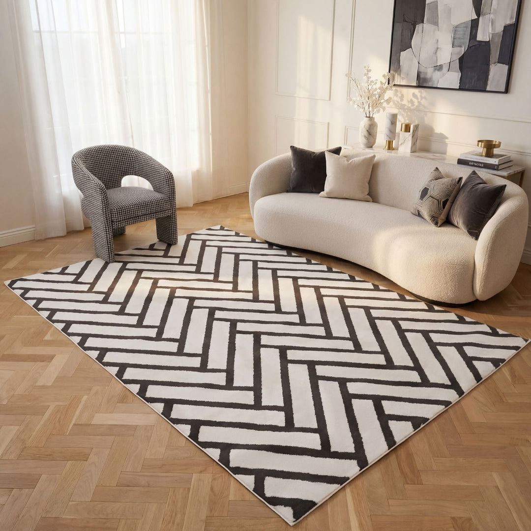 Living room with a black and white patterned rug, beige sofa, and decorative items.