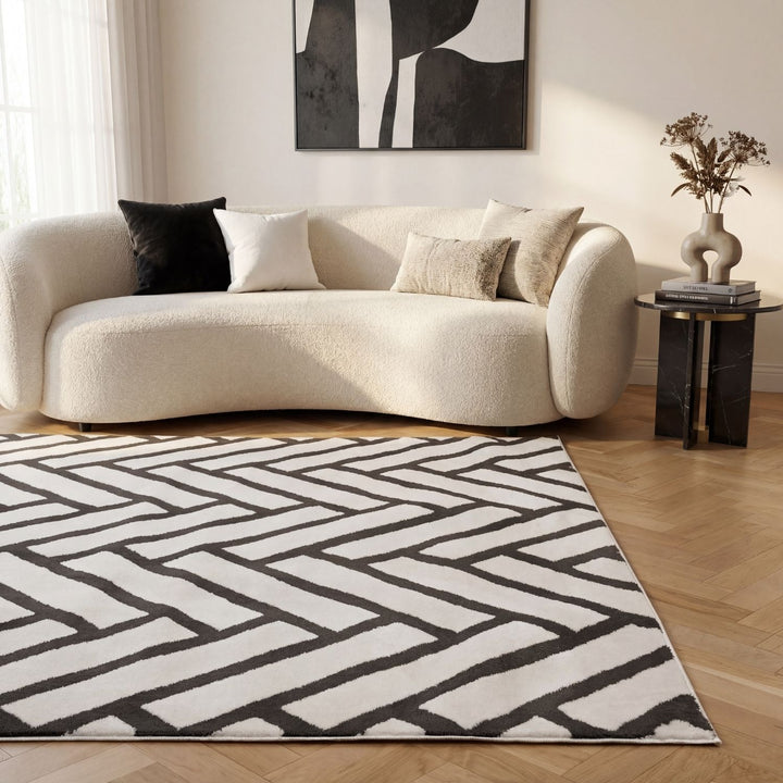 Modern living room with a geometric-patterned rug, beige sofa, and abstract art on the wall.