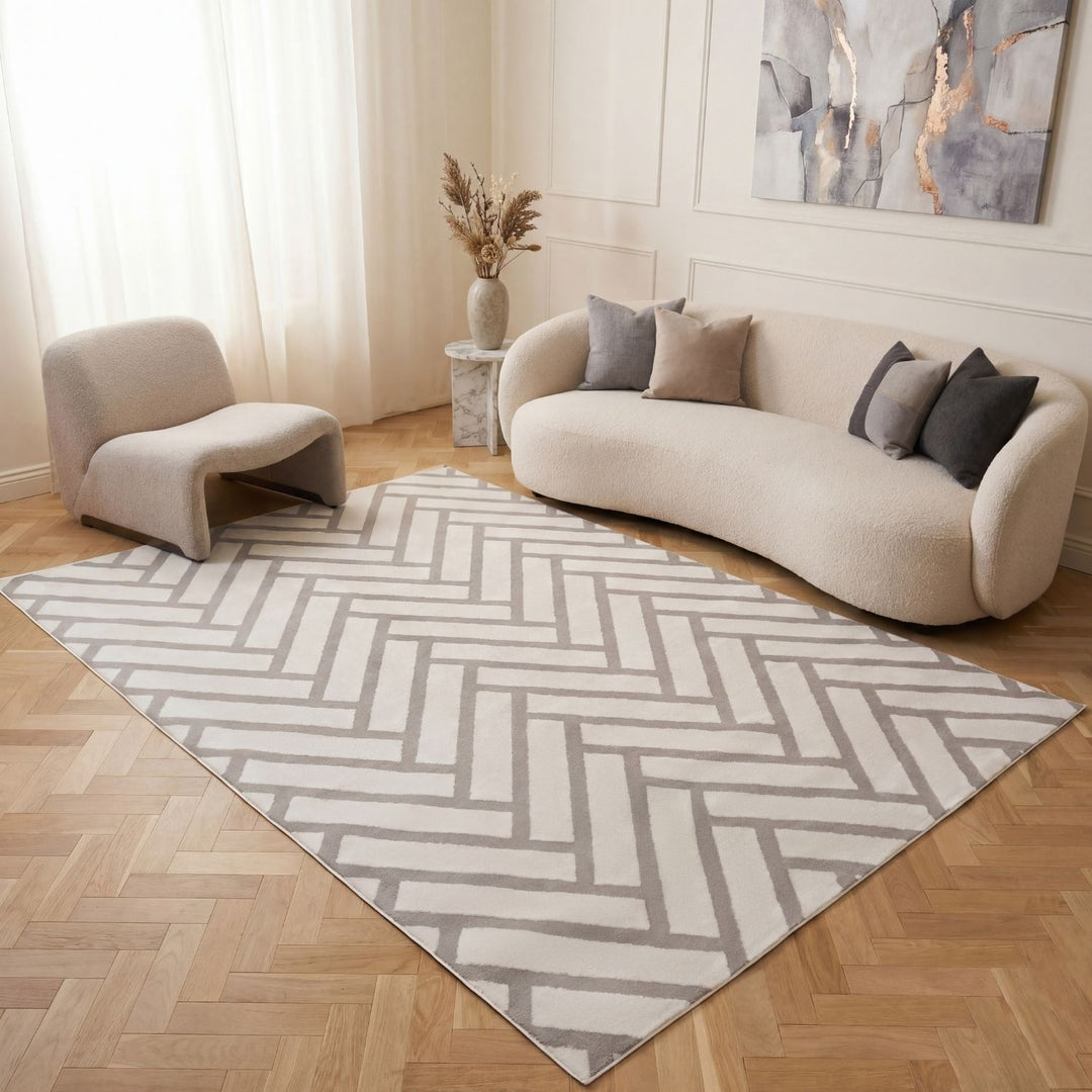 Living room with a chevron patterned rug, beige sofa, and armchair.
