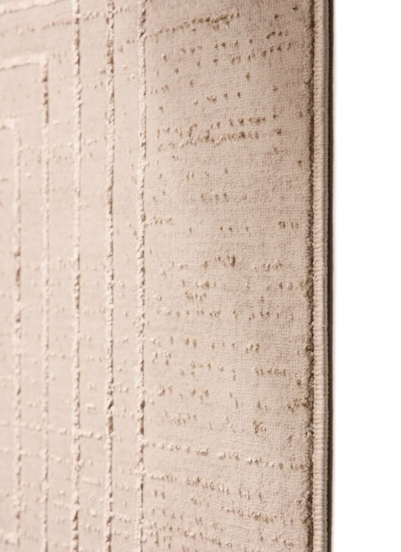 Close-up of an abstract striped geometric rug in neutral beige tones, showcasing its soft texture and sustainable design.