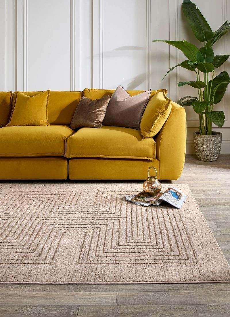 Abstract striped geometric rug in neutral tones under a yellow sofa, enhancing a modern living space.