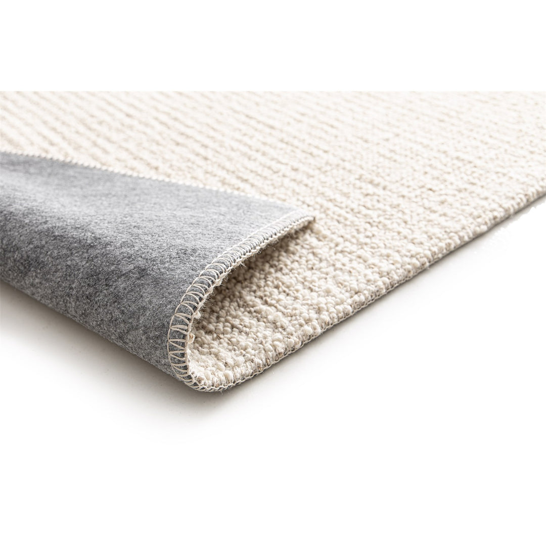 Dune Boucle cream textured rug, corner folded back to show the soft felt backing | The Rugs
