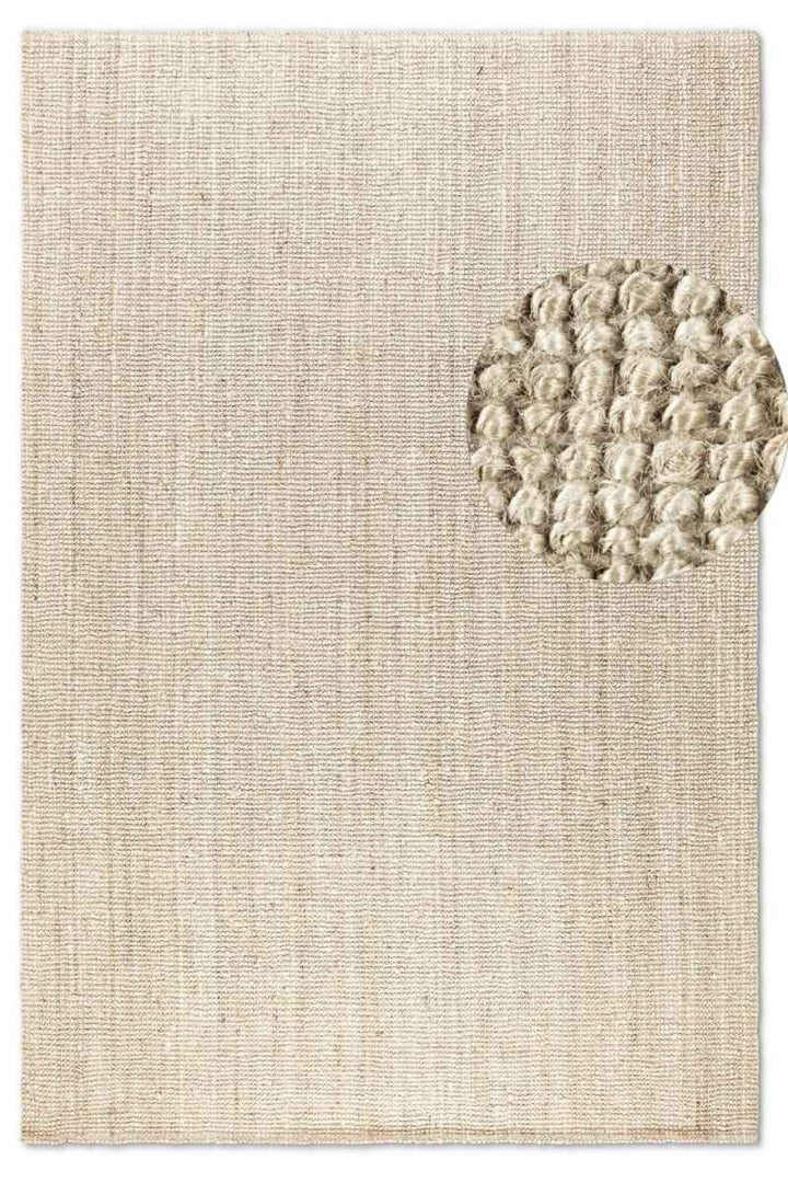 Textured beige rug with a circular pattern on a plain background