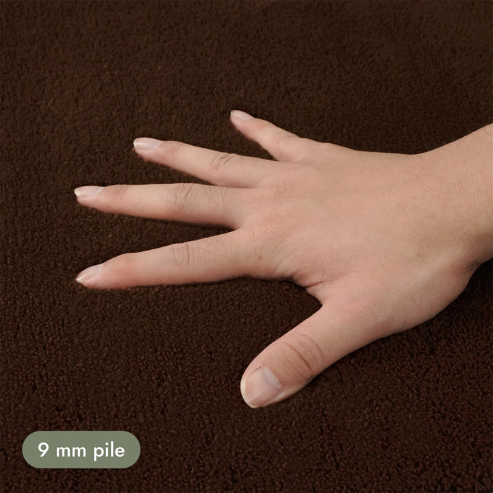 Washmellow dark brown washable rug, close-up of the soft 9mm pile under a hand | The Rugs