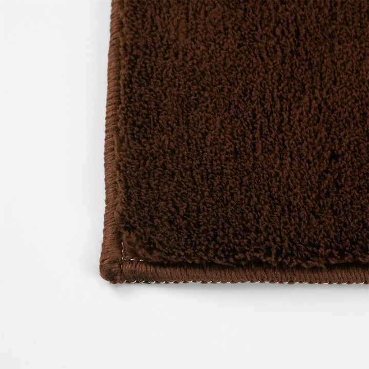 Washmellow dark brown washable rug, close-up of the corner and bound edge | The Rugs