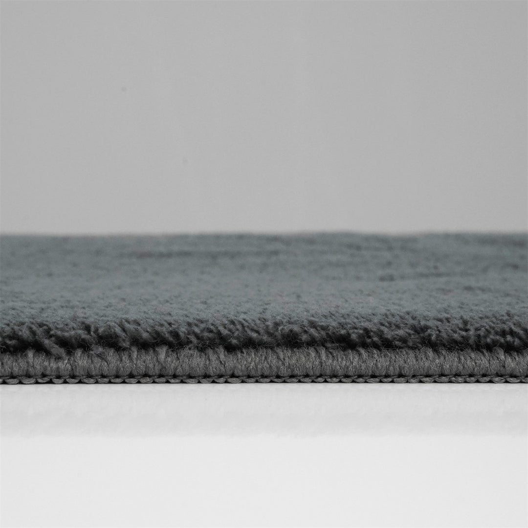 Washmellow dark grey washable rug, side view of the low pile and edge at floor level | The Rugs