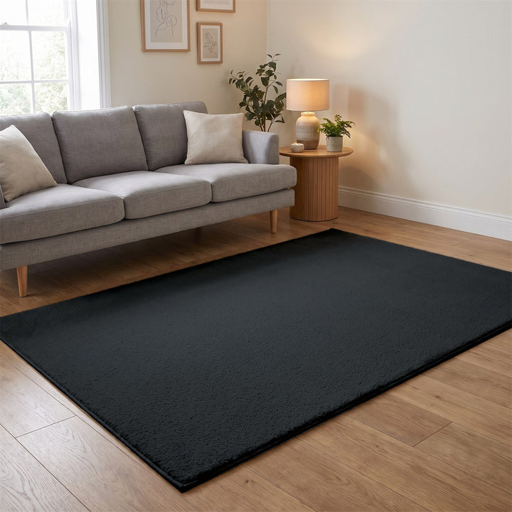 Washmellow dark grey washable rug in a living room with a grey sofa and oak floor | The Rugs