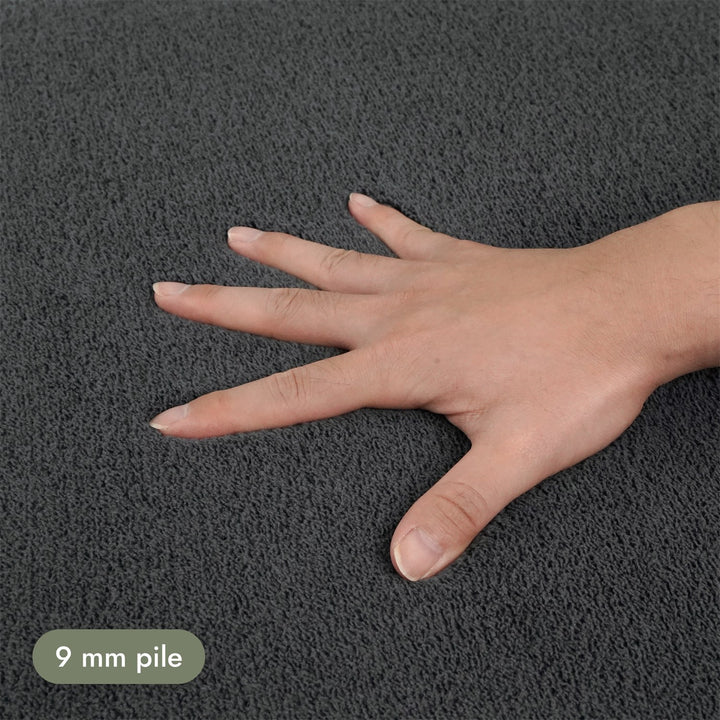 Washmellow dark grey washable rug, close-up of the soft 9mm pile under a hand | The Rugs