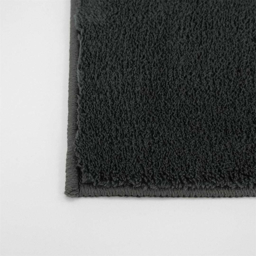 Washmellow dark grey washable rug, close-up of the corner and bound edge | The Rugs