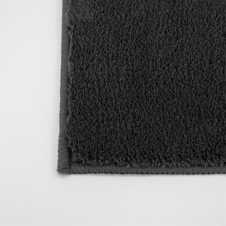 Washmellow dark grey washable rug, close-up of the corner and bound edge | The Rugs