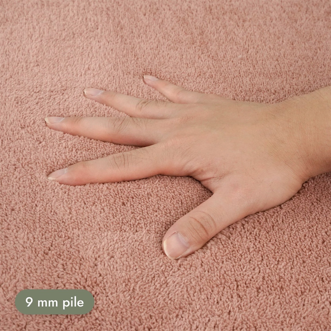 Washmellow dark pink washable rug, close-up of the soft 9mm pile under a hand | The Rugs