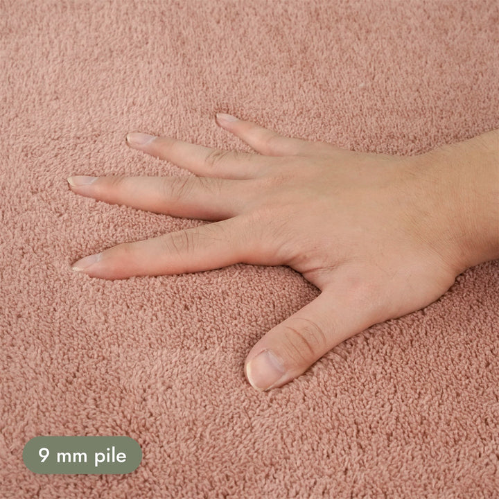 Washmellow dark pink washable rug, close-up of the soft 9mm pile under a hand | The Rugs