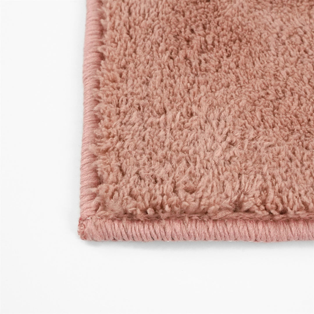 Washmellow dark pink washable rug, close-up of the corner and bound edge | The Rugs