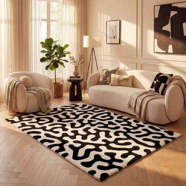 Living room with a black and white patterned rug, beige sofa, and armchair.