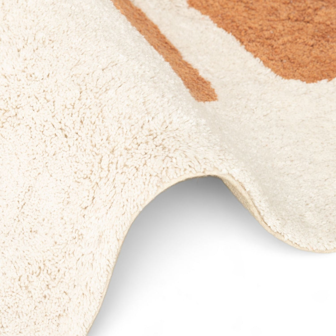 Close-up of a textured beige and brown rug corner on a white background