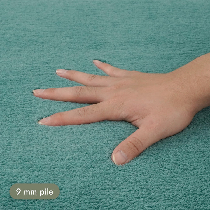 Washmellow duck egg blue washable rug, close-up of the soft 9mm pile under a hand | The Rugs