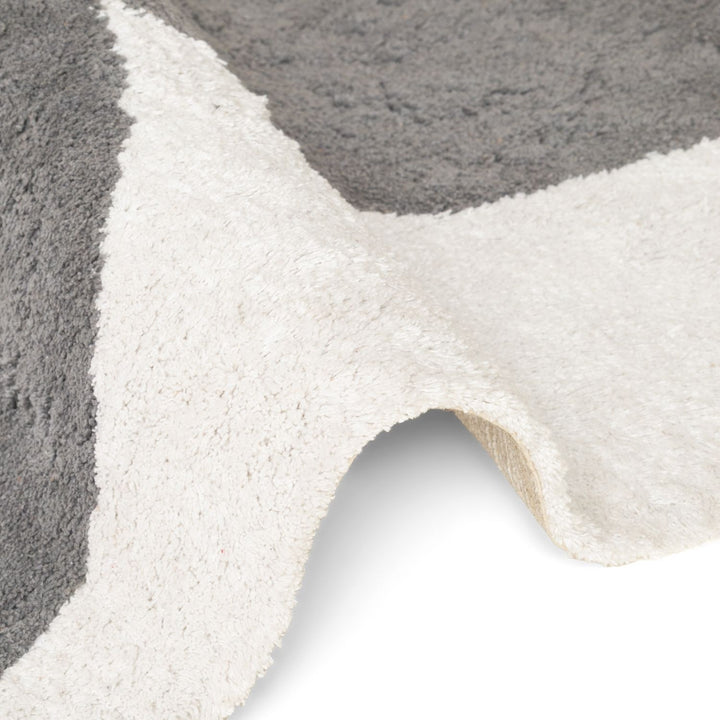 Close-up of a textured gray and white rug with a geometric pattern.