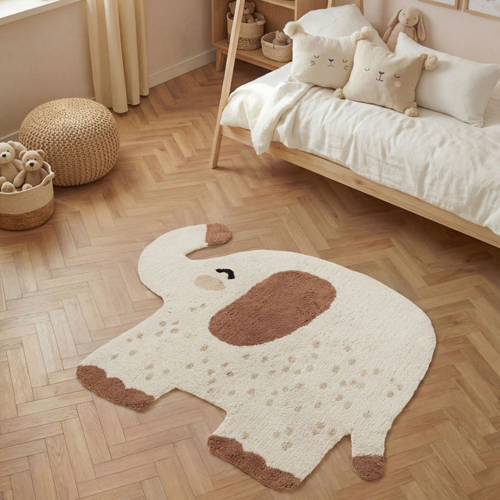 Children's room with a large elephant-shaped rug on a wooden floor.