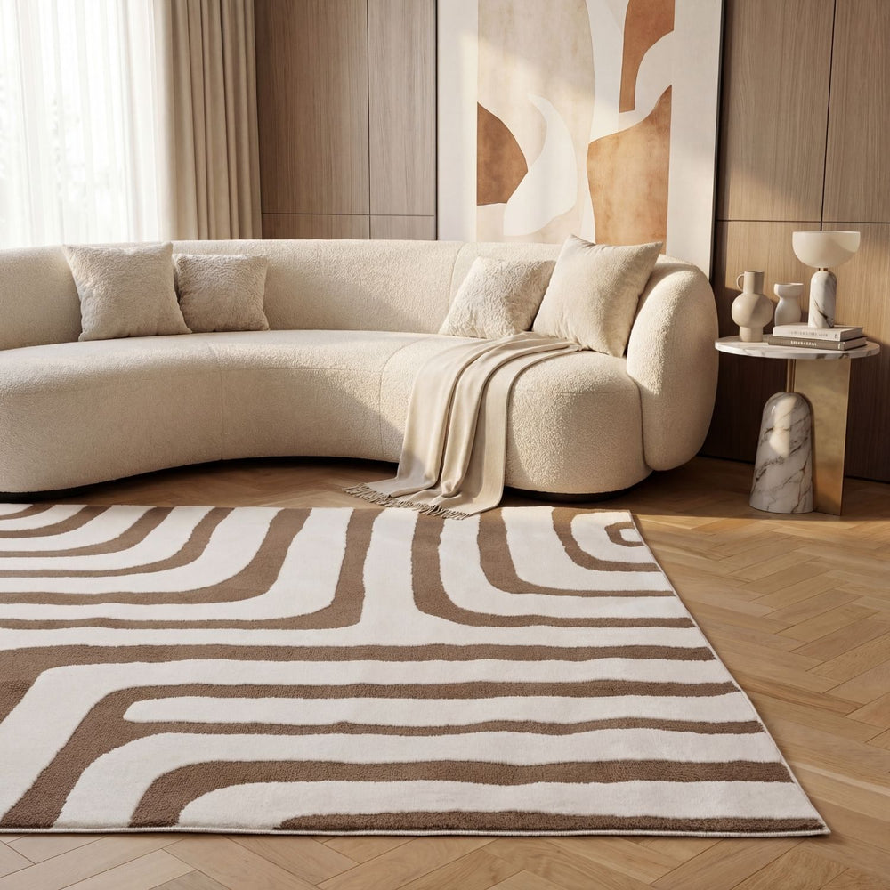 Modern living room with a beige sectional sofa and patterned rug.