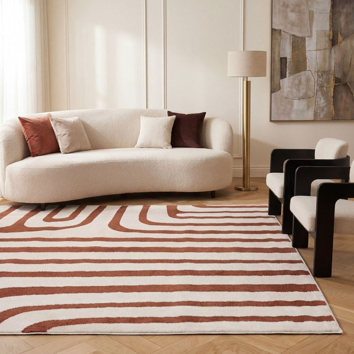 Modern living room with a striped rug, beige sofa, and abstract art on the wall.