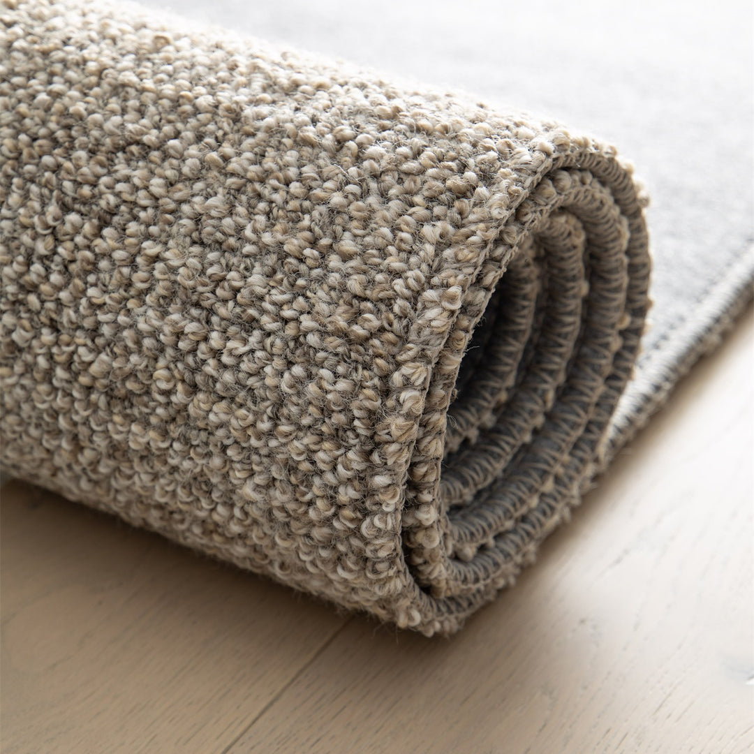 Dune Boucle greige textured rug, rolled up | The Rugs