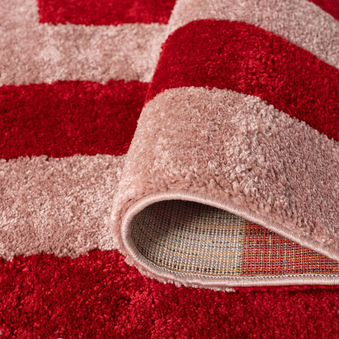 Close-up of a red and beige striped rug with a textured border.