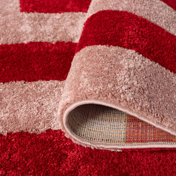 Close-up of a red and beige striped rug with a textured border.