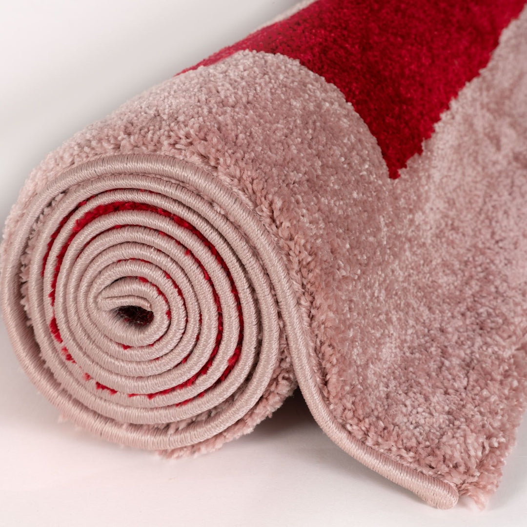 Roll of pink and red textured fabric on a white background