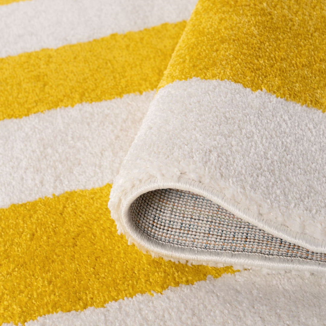 Close-up of a yellow and white striped rug with a textured edge.