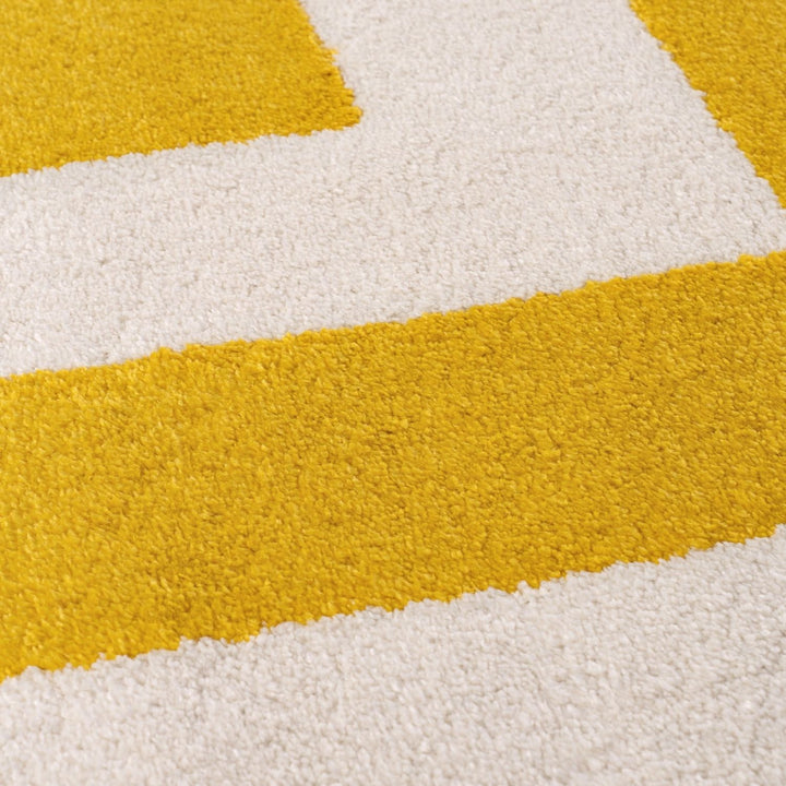 Close-up of a textured yellow and white rug with geometric pattern