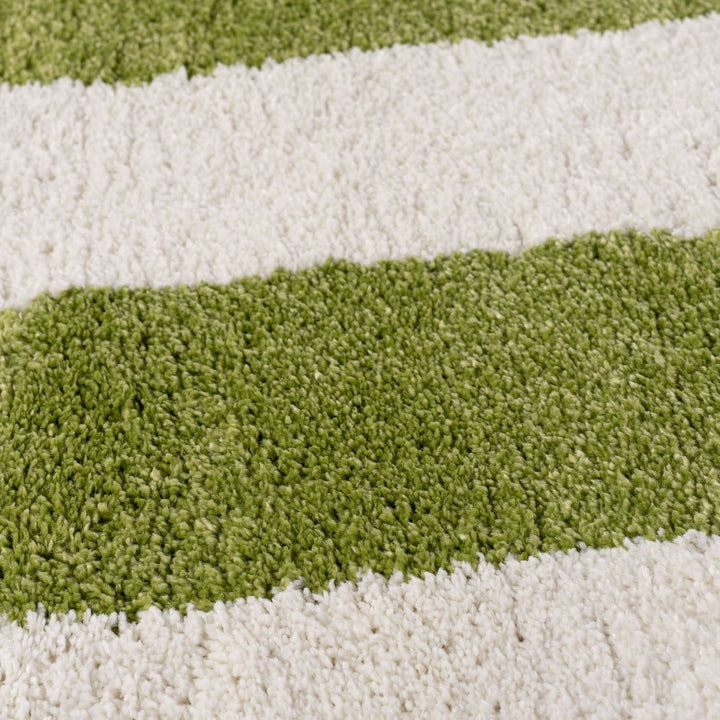 Close-up of a striped rug with green and white stripes.