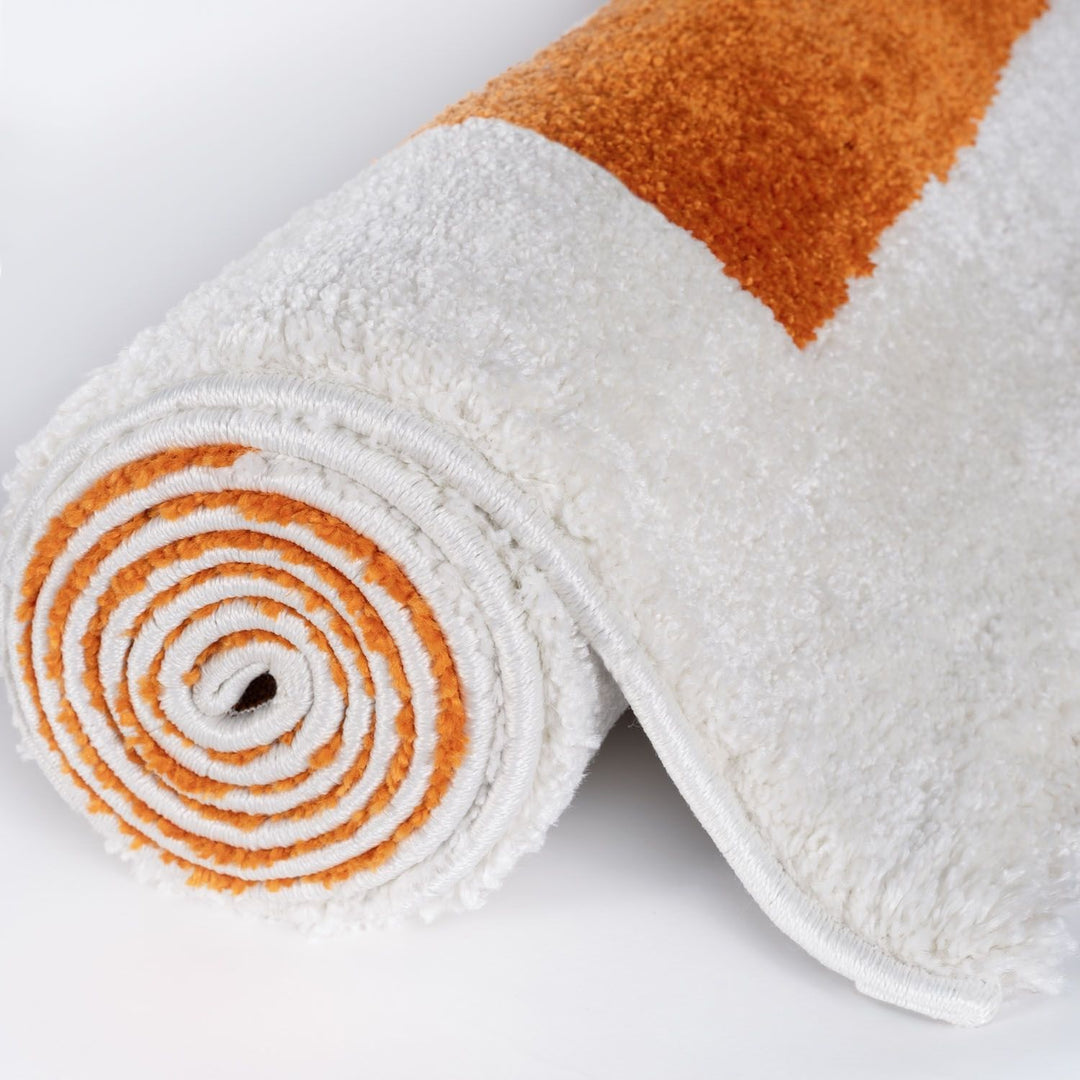 Rolled-up white and orange towel on a light gray background