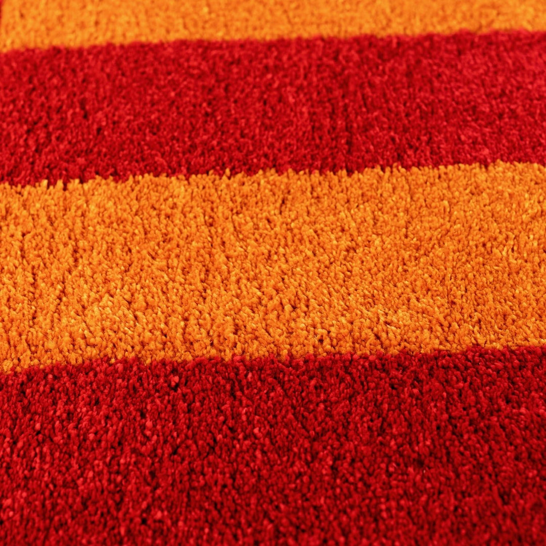 Close-up of a textured fabric with red and orange horizontal stripes.