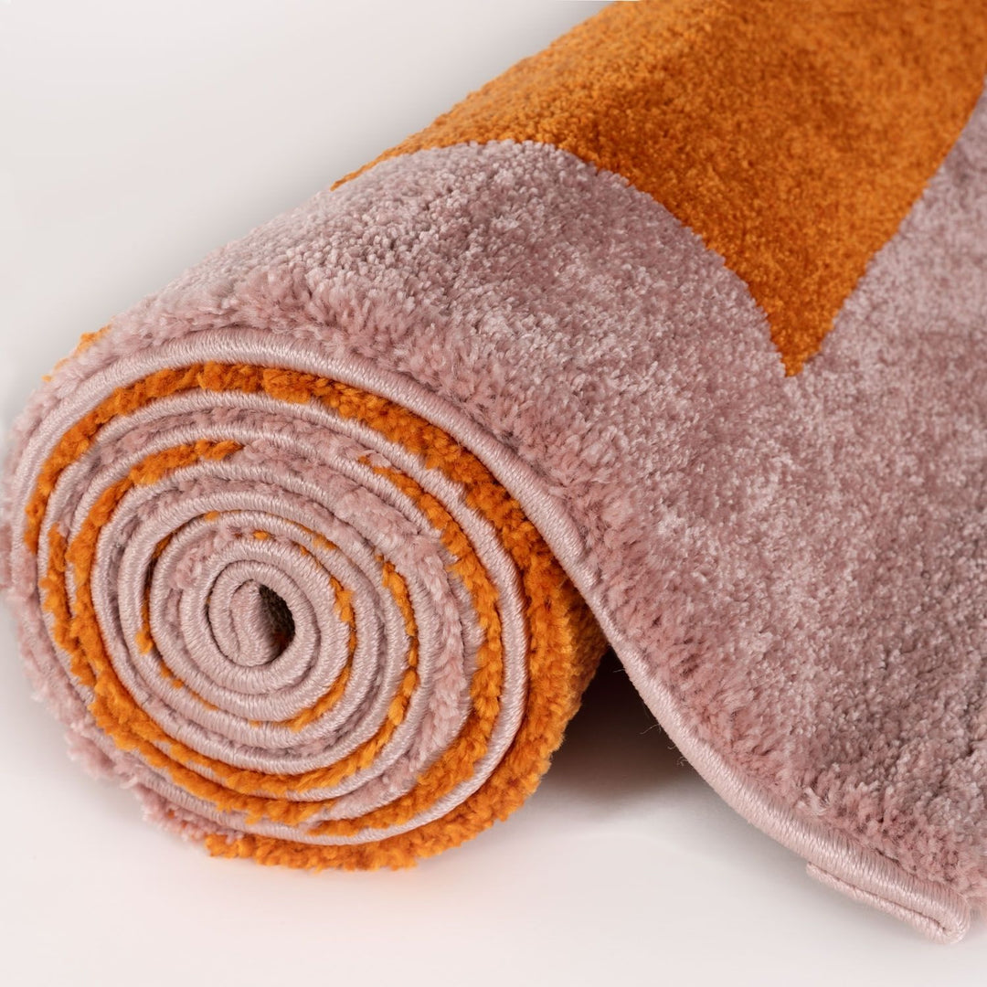 Rolled-up multicolored rug with orange and pink hues on a white background