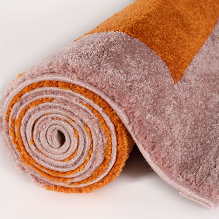 Rolled-up multicolored rug with orange and pink hues on a white background