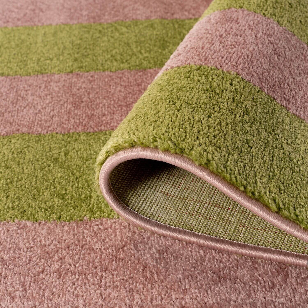 Close-up of a green and brown striped rug with a rolled edge.