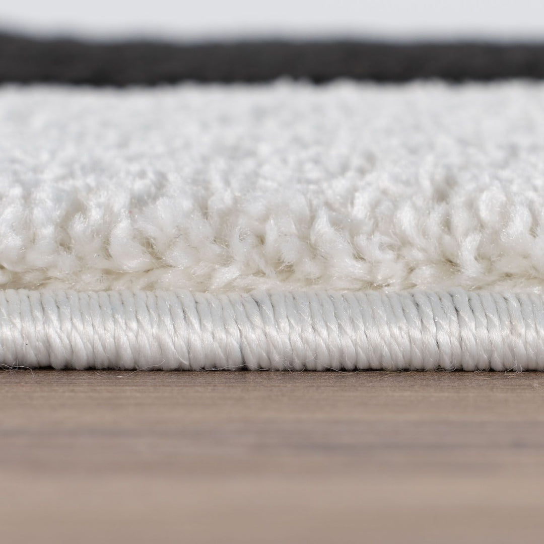 Close-up of a white textured rug on a wooden floor