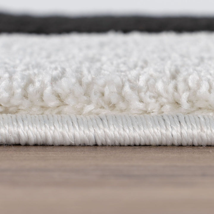 Close-up of a white textured rug on a wooden floor