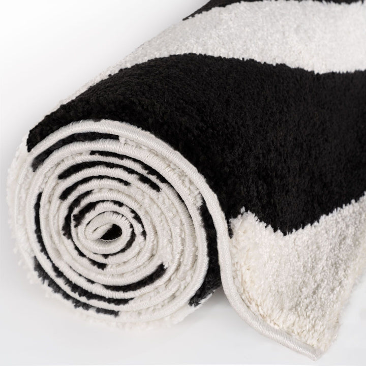 Black and white striped rug rolled up on a white background